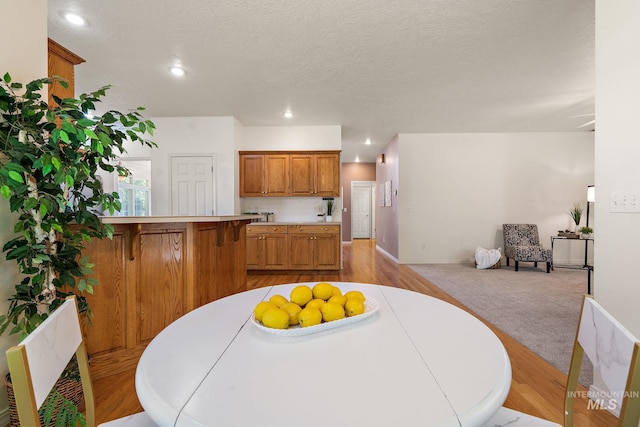 dining room with recessed lighting, light wood finished floors, and baseboards