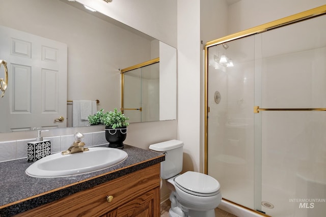 bathroom featuring a stall shower, toilet, and vanity