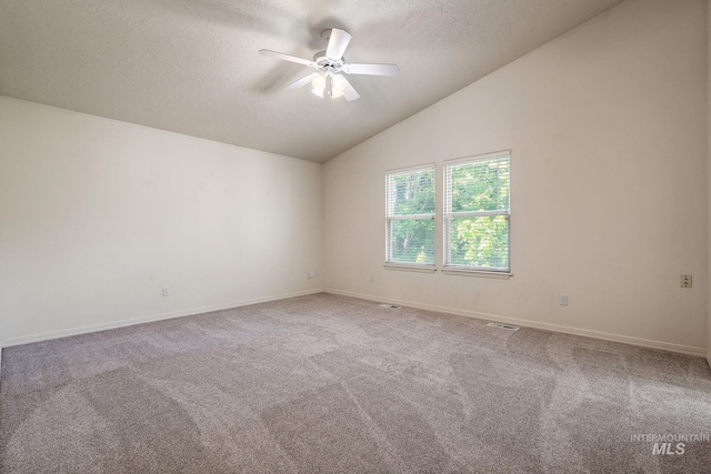 spare room with a ceiling fan, a textured ceiling, carpet floors, lofted ceiling, and baseboards