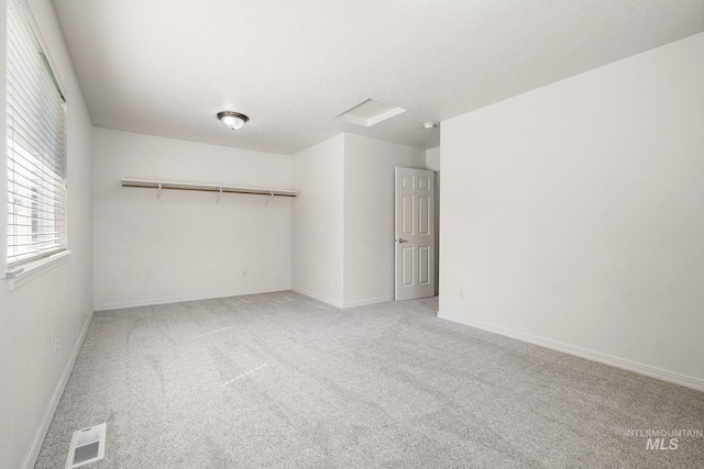 unfurnished bedroom featuring carpet, baseboards, and a textured ceiling