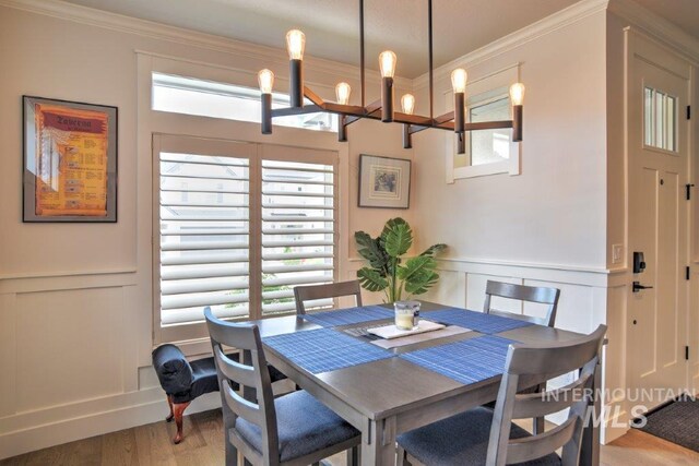 dining space featuring a wealth of natural light, crown molding, and light hardwood / wood-style flooring