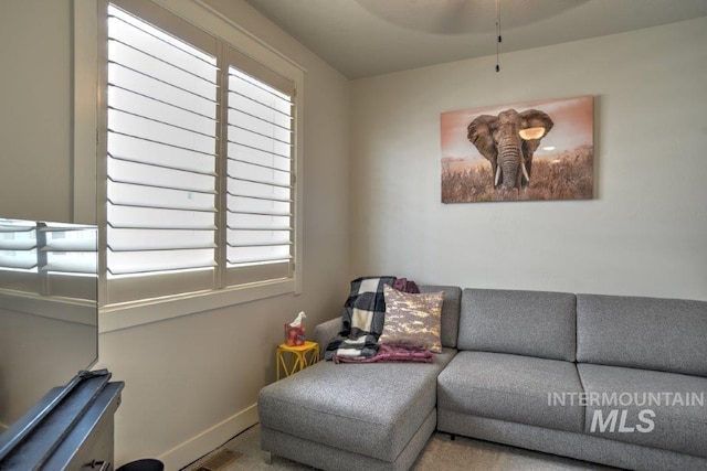 living area featuring a healthy amount of sunlight, visible vents, and baseboards