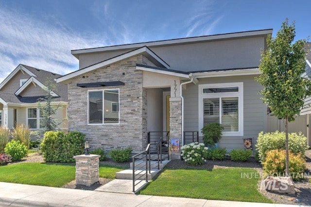 view of front facade featuring stone siding and a front yard