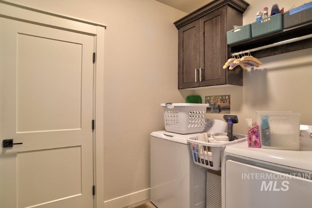 clothes washing area featuring independent washer and dryer and cabinets