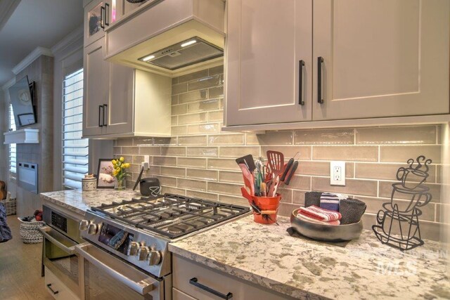 kitchen with appliances with stainless steel finishes, light stone counters, and tasteful backsplash