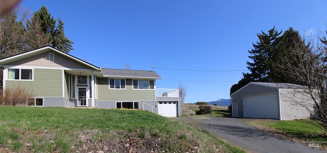 view of front of house featuring a front lawn, an outdoor structure, and a garage