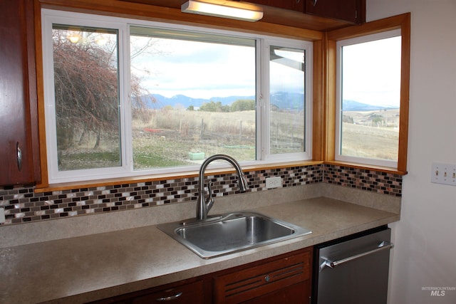 kitchen featuring a sink, backsplash, a mountain view, and dishwasher