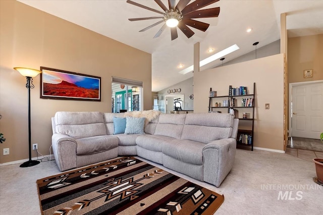 carpeted living room featuring a skylight and high vaulted ceiling