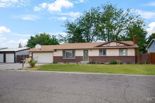 ranch-style house with fence, an attached garage, a front lawn, concrete driveway, and brick siding