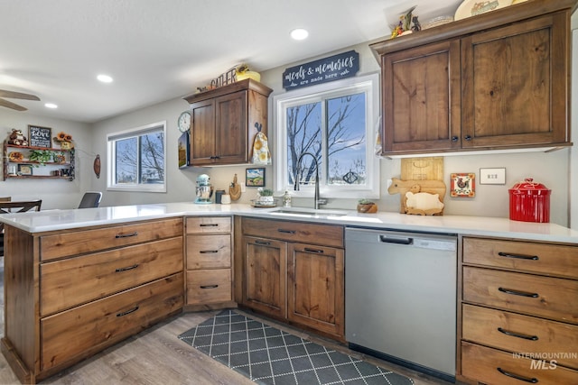 kitchen featuring ceiling fan, sink, stainless steel dishwasher, kitchen peninsula, and light wood-type flooring
