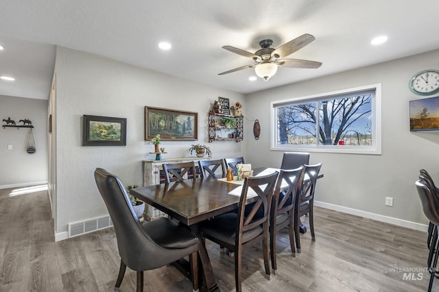 dining space featuring wood-type flooring and ceiling fan