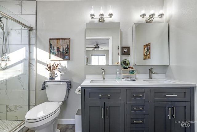 bathroom featuring vanity, ceiling fan, hardwood / wood-style floors, toilet, and a shower with shower door