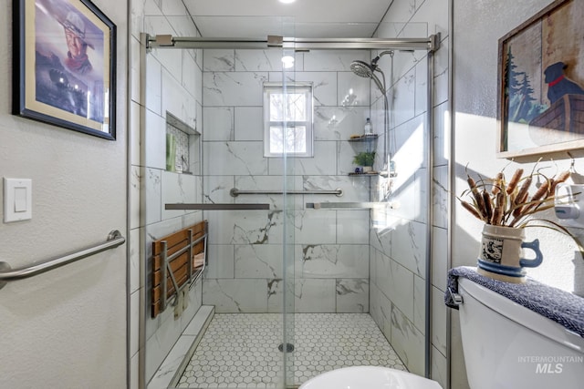 bathroom with toilet and a shower with door
