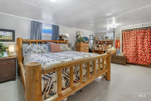 bedroom featuring light carpet and a textured ceiling