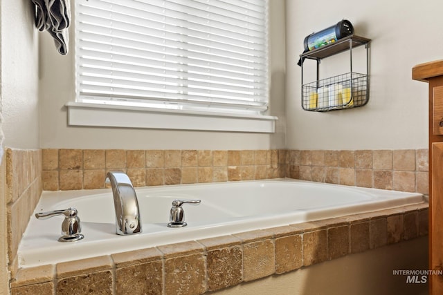 bathroom featuring a healthy amount of sunlight and tiled bath