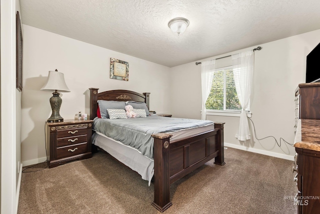 bedroom featuring a textured ceiling and dark colored carpet