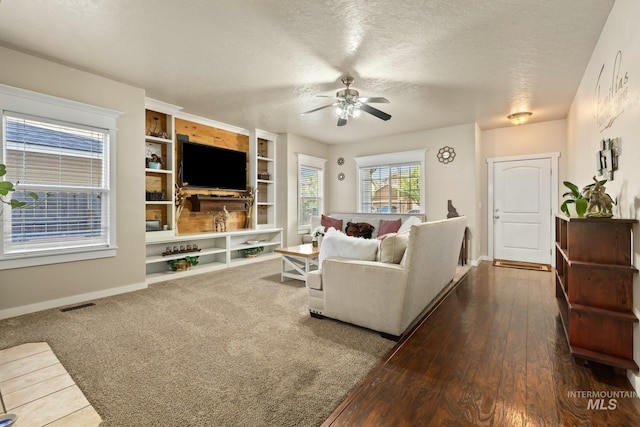 living room with ceiling fan, a textured ceiling, and dark hardwood / wood-style flooring