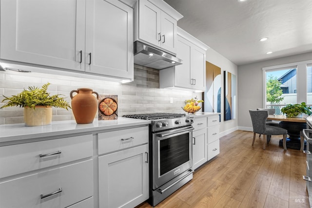 3067 N Sun City Ave, Star, ID 83669 - kitchen with stainless steel stove, under cabinet range hood, light countertops, light wood-type flooring, and tasteful backsplash