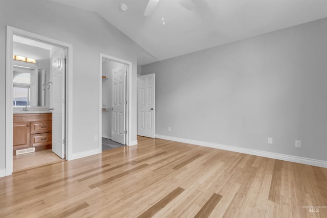 4104 Iris Ct, Nampa, ID 83687 - unfurnished bedroom featuring light wood-style floors, vaulted ceiling, a walk in closet, and baseboards
