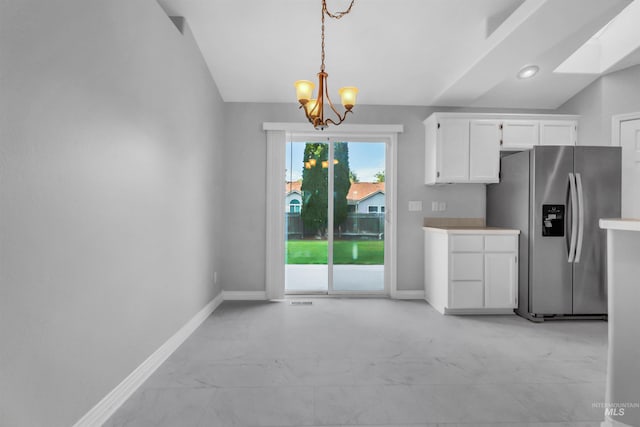 4104 Iris Ct, Nampa, ID 83687 - kitchen featuring stainless steel refrigerator with ice dispenser, baseboards, white cabinets, a chandelier, and lofted ceiling