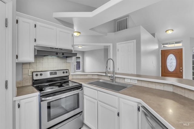4104 Iris Ct, Nampa, ID 83687 - kitchen featuring appliances with stainless steel finishes, under cabinet range hood, a sink, tasteful backsplash, and white cabinets