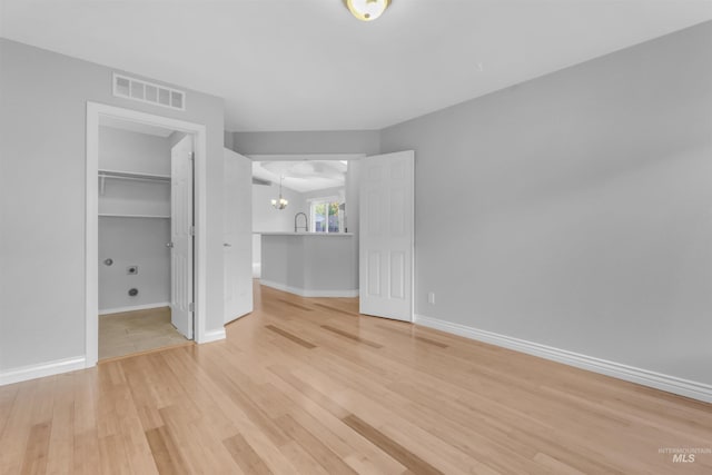 4104 Iris Ct, Nampa, ID 83687 - unfurnished bedroom with light wood-style flooring, a chandelier, baseboards, a walk in closet, and a closet