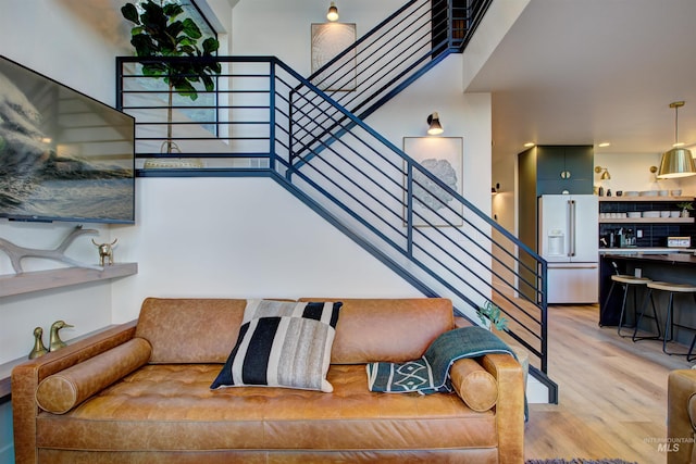 living area with stairs and light wood-style flooring