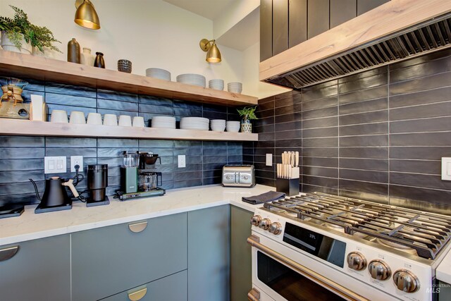 kitchen with backsplash, white gas stove, light stone counters, range hood, and open shelves