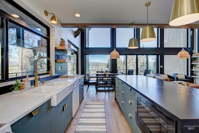 kitchen with a sink, decorative light fixtures, recessed lighting, light wood-style floors, and dishwasher