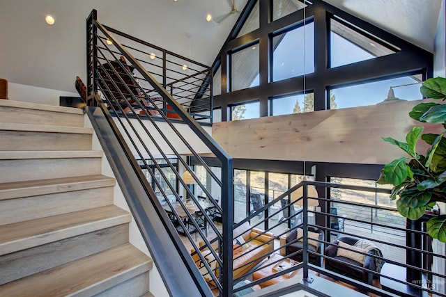 staircase featuring a wealth of natural light and high vaulted ceiling