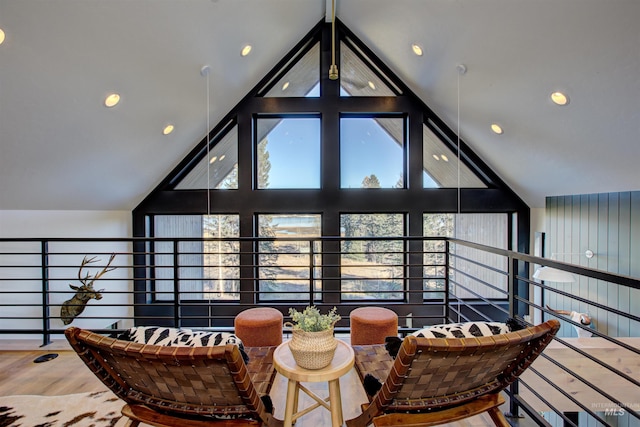 living area with high vaulted ceiling and wood finished floors