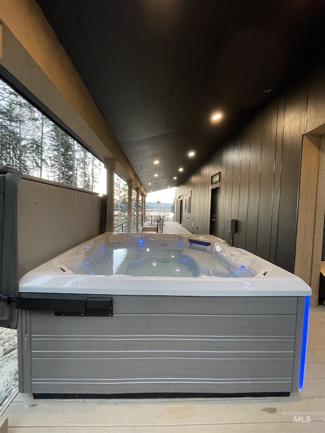 misc room with wood walls and a hot tub