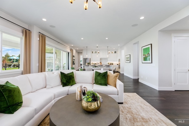 living room with dark hardwood / wood-style floors and a chandelier