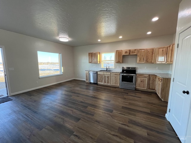 kitchen featuring stainless steel appliances, dark wood-style flooring, a sink, baseboards, and light countertops