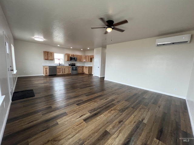 unfurnished living room featuring dark wood-style floors, an AC wall unit, a sink, and baseboards