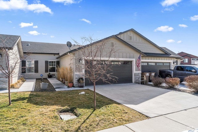 view of front of property with board and batten siding, a front lawn, driveway, and an attached garage