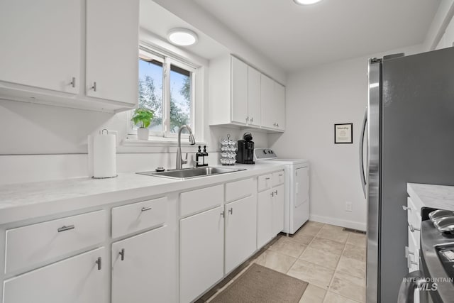 kitchen with a sink, light countertops, stainless steel appliances, white cabinetry, and washer and dryer