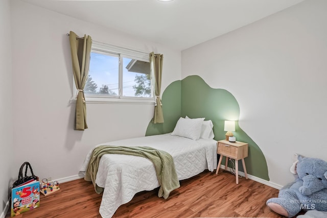 bedroom featuring baseboards and wood finished floors