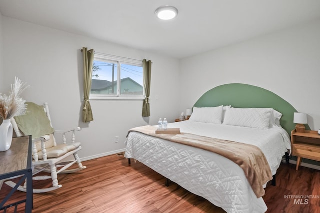 bedroom with baseboards and wood finished floors