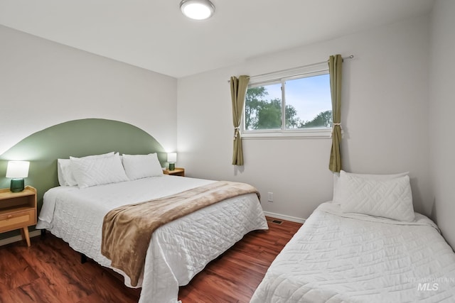 bedroom featuring baseboards and wood finished floors