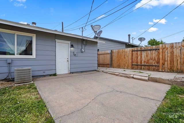 rear view of house featuring fence, central AC, and a patio area