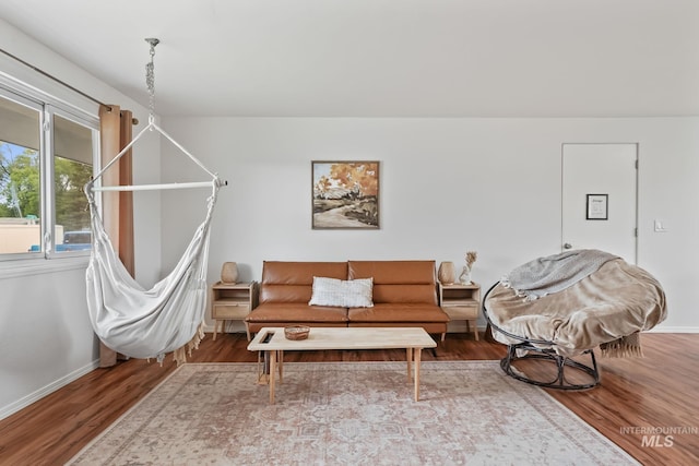 living area with baseboards and wood finished floors
