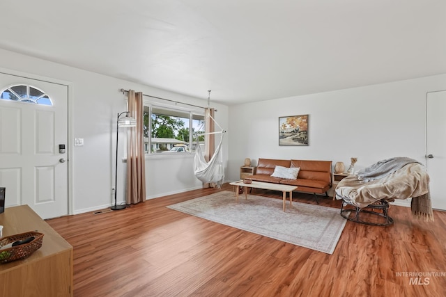 living area featuring baseboards and wood finished floors