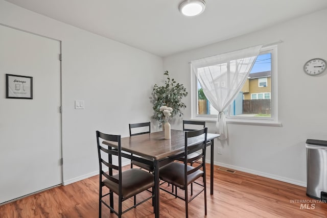 dining space featuring baseboards, light wood-style flooring, and visible vents