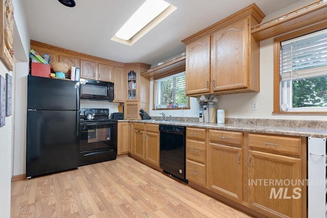 1015 E Park, Weiser, ID 83672 - kitchen with black appliances, light wood-type flooring, light countertops, and glass insert cabinets