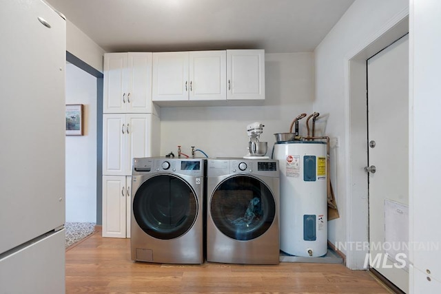 1015 E Park, Weiser, ID 83672 - washroom featuring water heater, cabinet space, light wood-style floors, and washing machine and clothes dryer