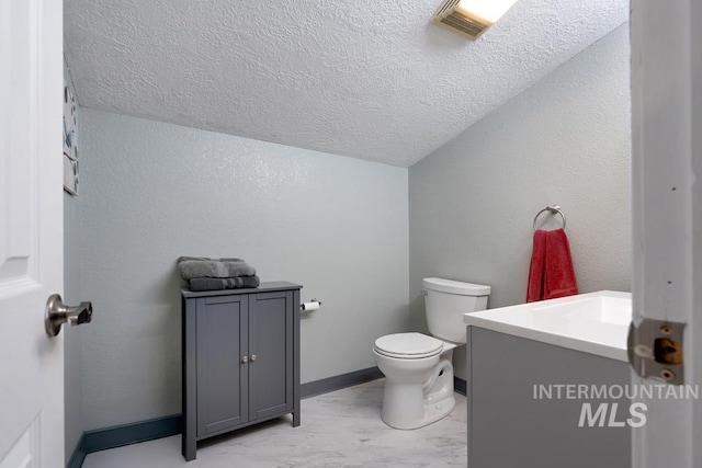 1015 E Park, Weiser, ID 83672 - half bathroom featuring vanity, a textured ceiling, vaulted ceiling, and a textured wall