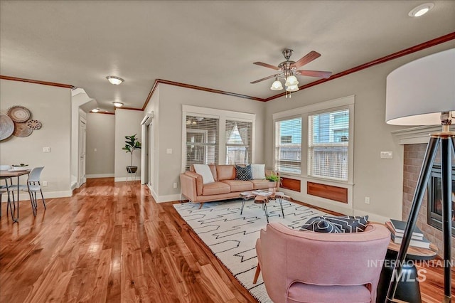 1512 N 28th St, Boise, ID 83703 - living area featuring light wood-style floors, ceiling fan, a brick fireplace, crown molding, and baseboards
