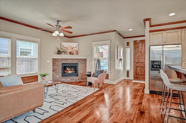 1512 N 28th St, Boise, ID 83703 - living area with light wood-style floors, crown molding, healthy amount of natural light, a brick fireplace, and a ceiling fan