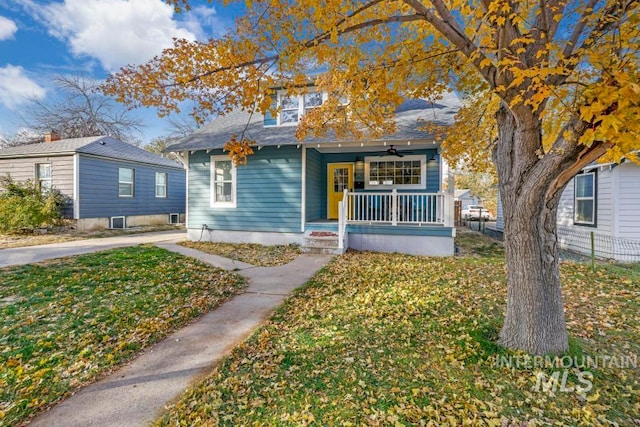 bungalow with covered porch and a front yard